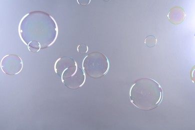 Photo of Beautiful transparent soap bubbles on gray background