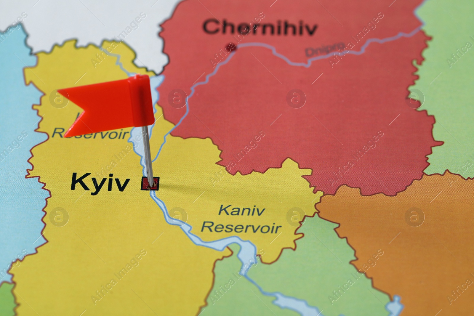 Photo of Map of Ukraine with red flag push pin placed on Kyiv, closeup