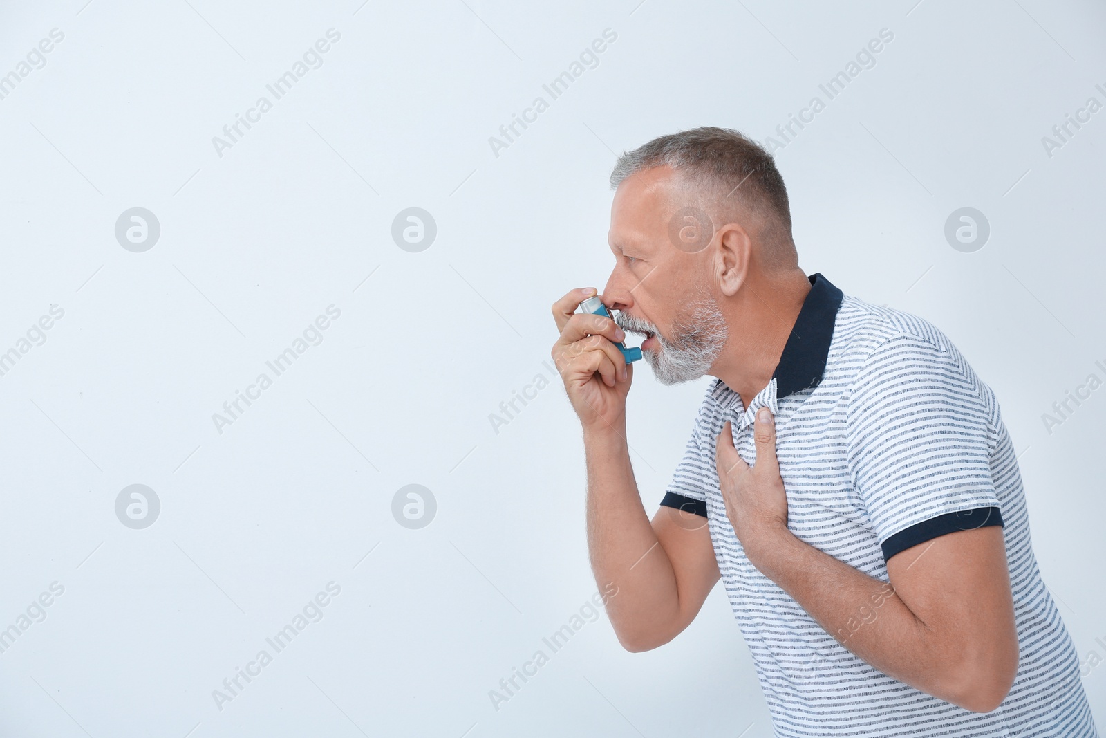 Photo of Man using asthma inhaler on white background