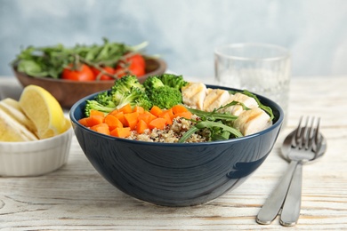 Photo of Ceramic bowl with quinoa and garnish on table