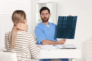Doctor with neck MRI scan consulting patient in hospital