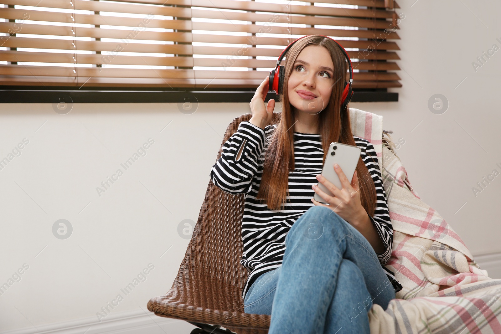 Photo of Woman listening to audiobook in chair at home