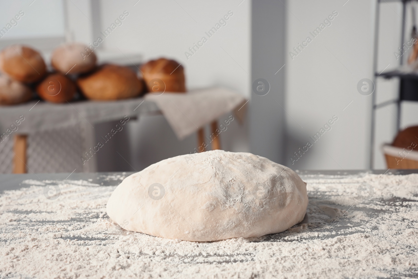 Photo of Fresh dough with flour on table in kitchen