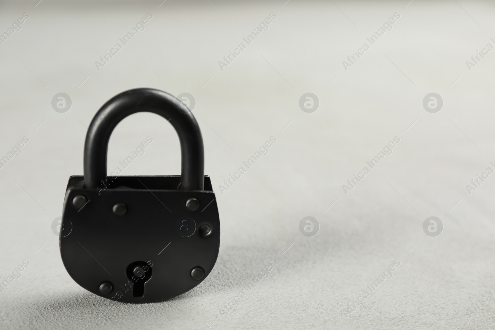Photo of Vintage padlock on light table. Space for text