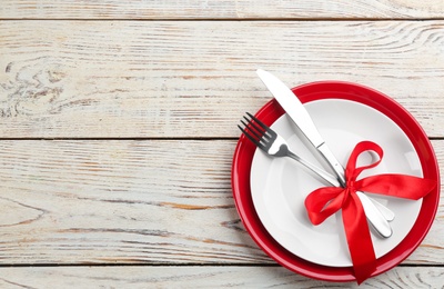 Beautiful table setting on white wooden background, top view with space for text. Valentine's Day dinner