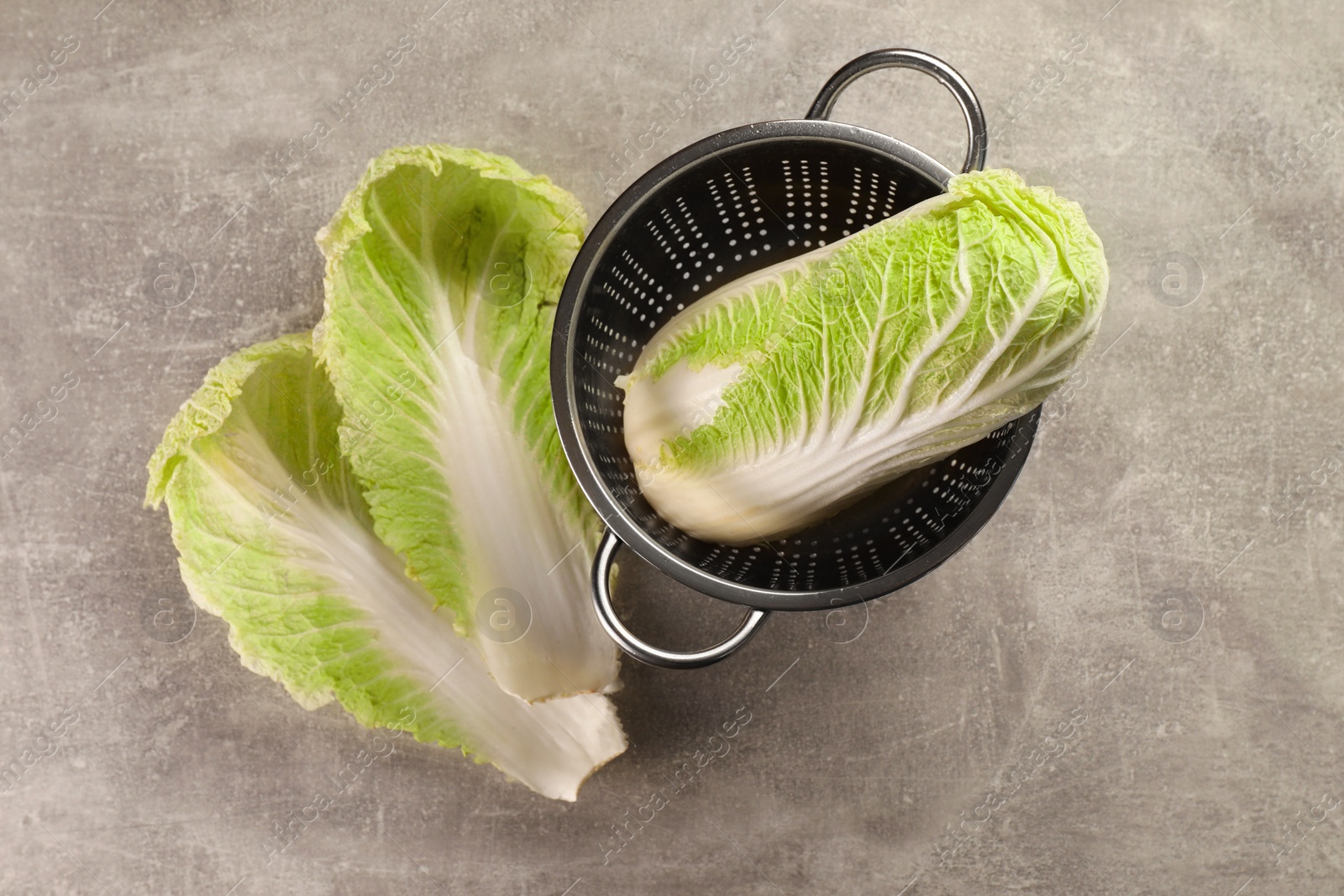 Photo of Fresh ripe Chinese cabbage and leaves on light grey table, flat lay