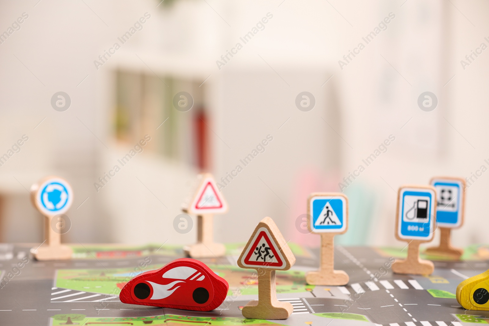 Photo of Set of wooden road signs and car indoors, closeup. Children's toys