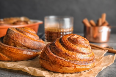 Parchment with freshly baked cinnamon rolls on table, closeup