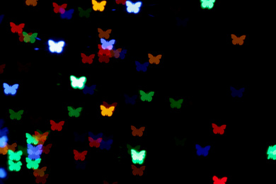 Photo of Blurred view of butterfly shaped lights on black background. Bokeh effect