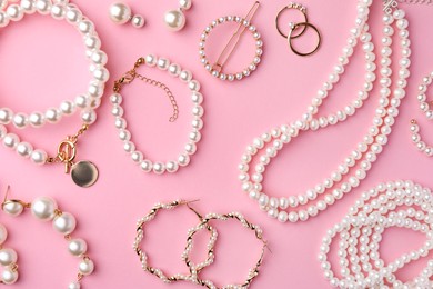 Elegant pearl jewelry on pink background, flat lay