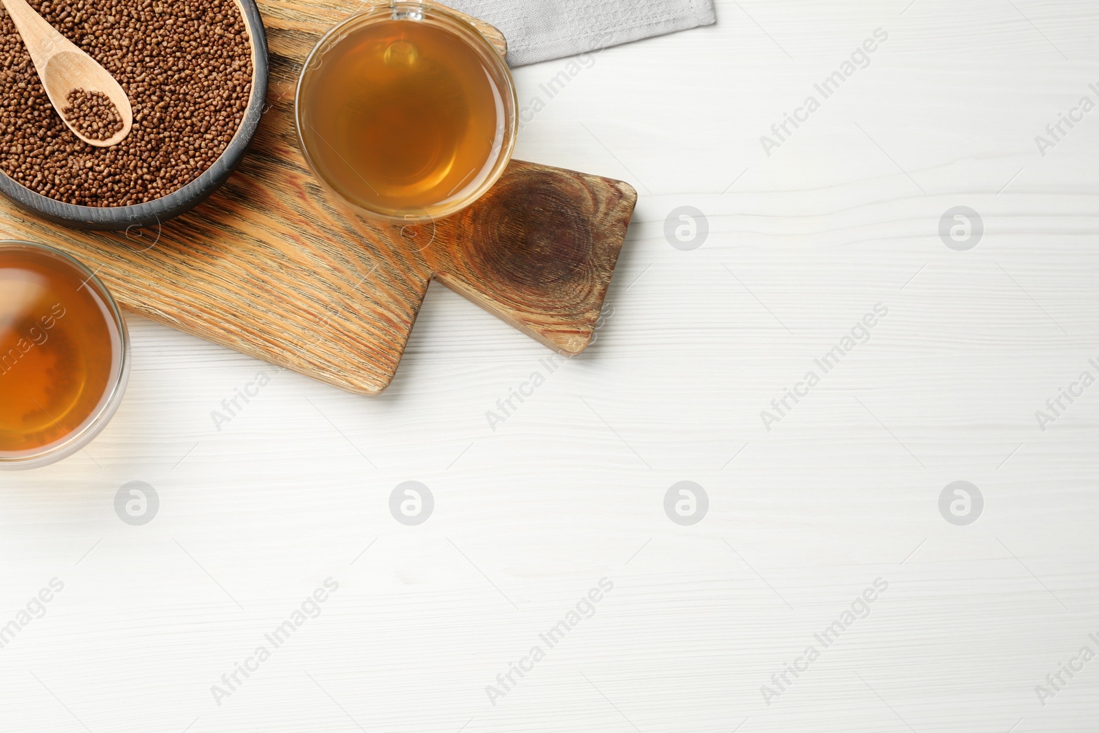 Photo of Delicious buckwheat tea and granules on white wooden table, flat lay. Space for text