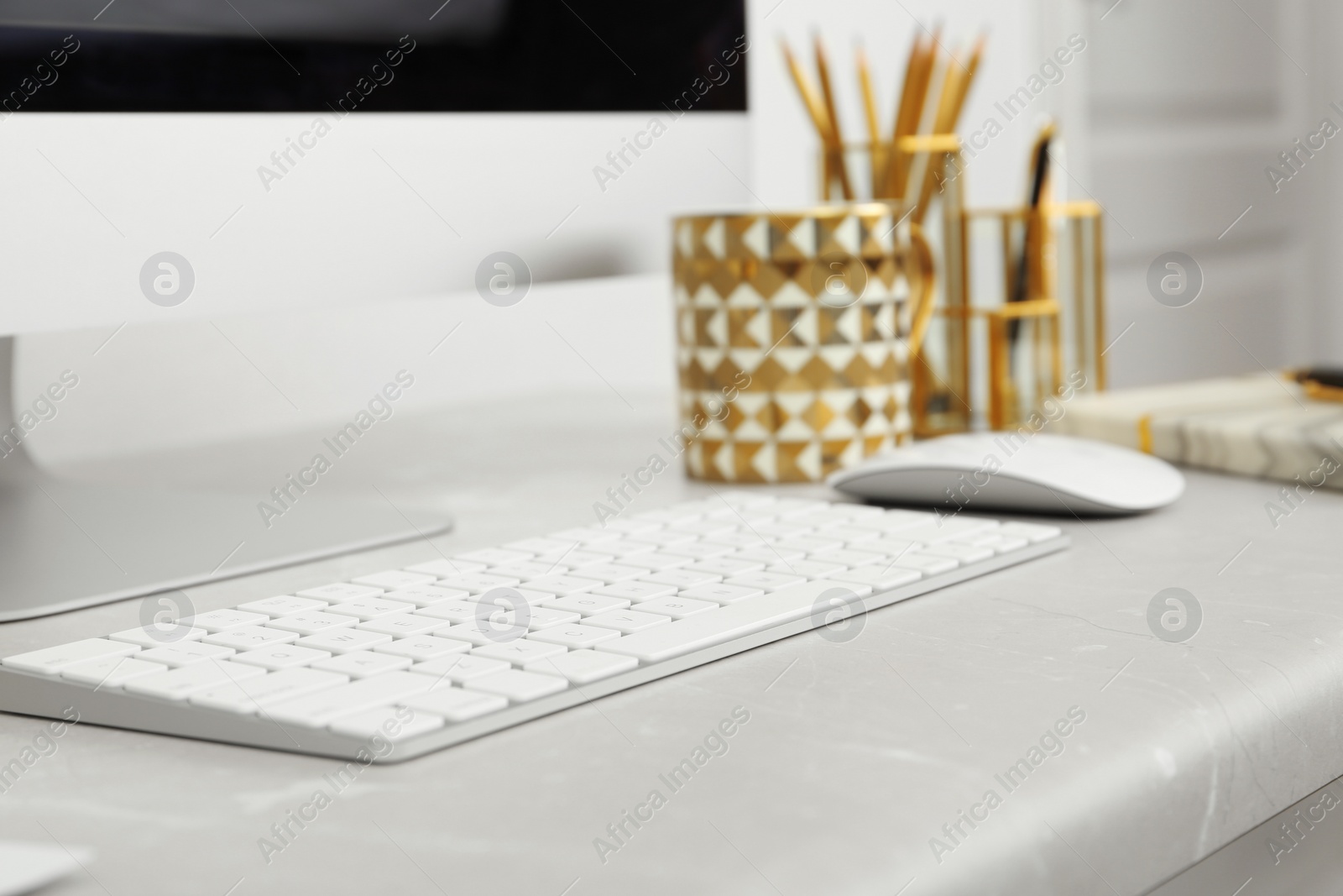 Photo of Stylish workplace with different golden accessories indoors. Idea for interior design