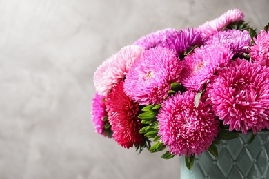 Photo of Vase with beautiful aster flowers on beige background, closeup. Space for text