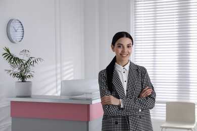 Photo of Portrait of receptionist near countertop in office, space for text