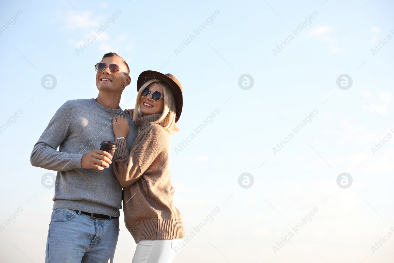 Photo of Happy couple in stylish sweaters outdoors on sunny day