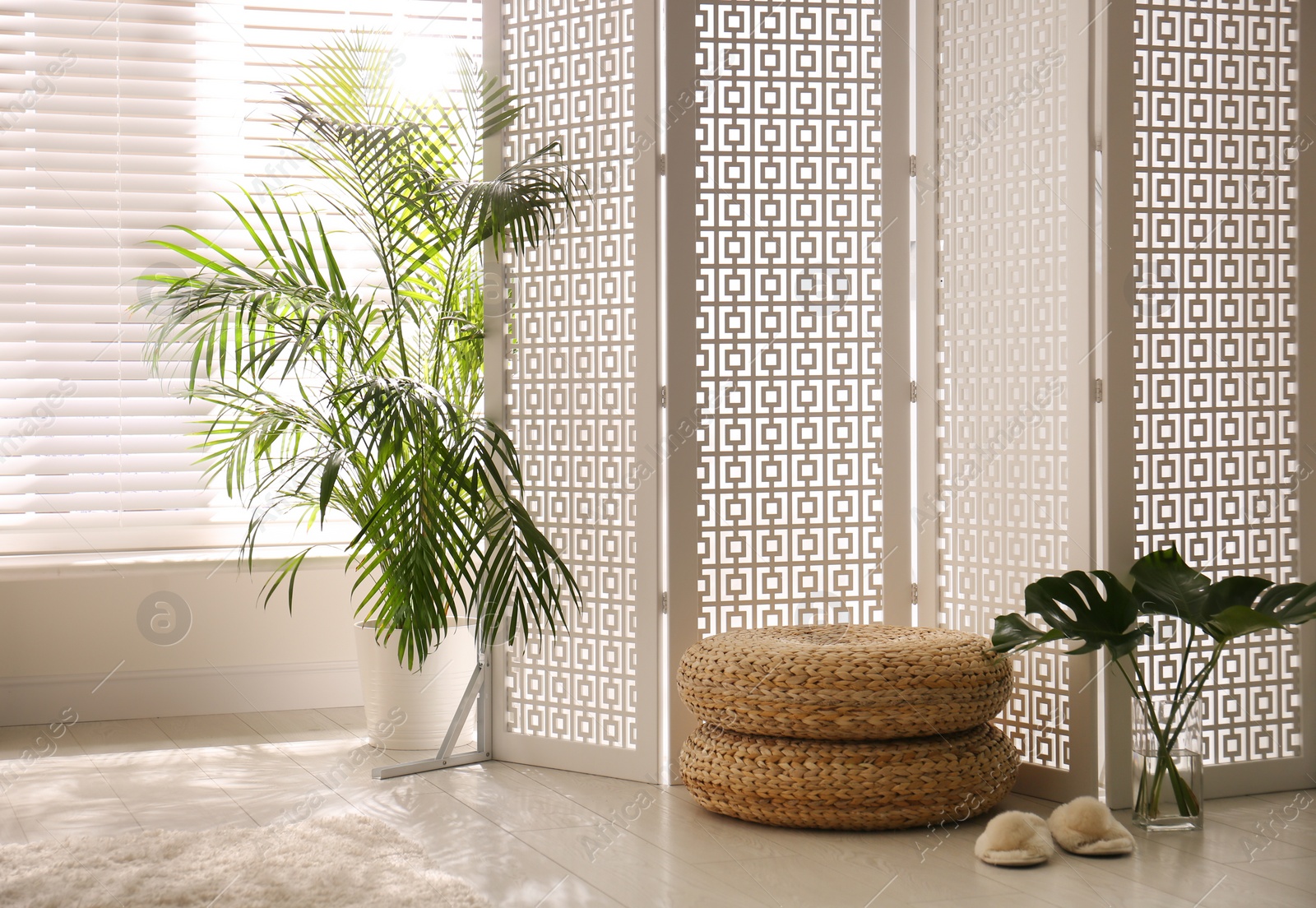 Photo of Stylish room interior with white folding screen and plants