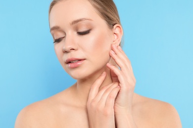 Photo of Portrait of young woman with beautiful face on blue background, closeup