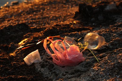 Photo of Plastic garbage at beach, closeup and space for text. Environmental pollution concept