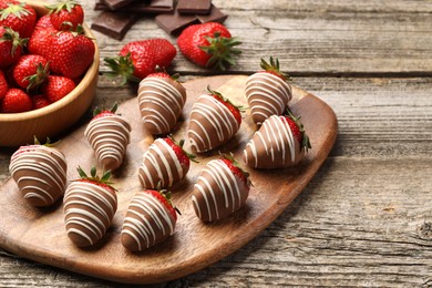 Photo of Delicious chocolate covered strawberries on wooden table. Space for text