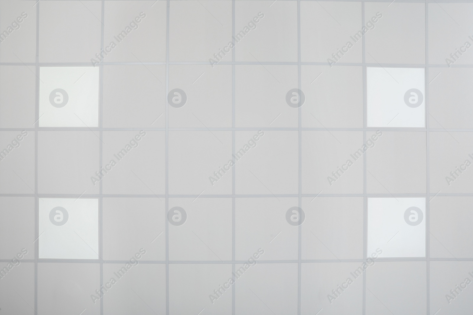 Photo of White ceiling with modern lighting in room, bottom view