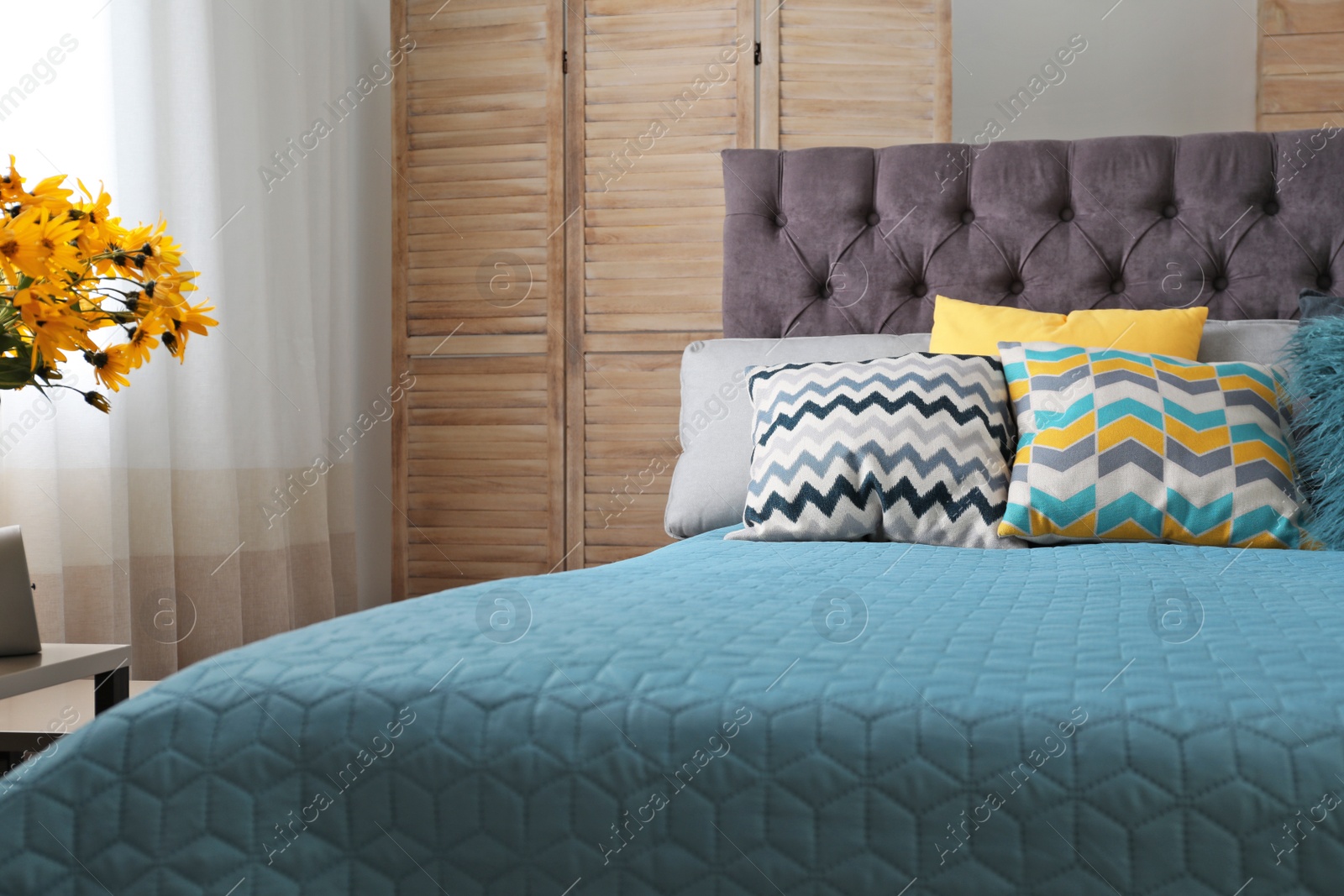 Photo of Different pillows on bed in room. Idea for interior decor