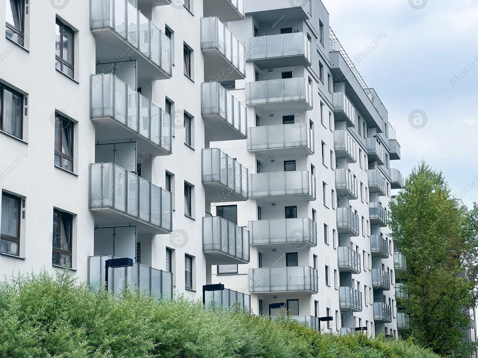 Photo of Exterior of beautiful residential building with balconies on city street