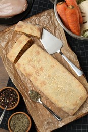 Photo of Delicious strudel with chicken and vegetables served on wooden table, flat lay