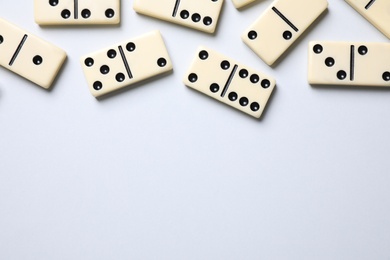 Photo of Classic domino tiles on white background, flat lay. Space for text