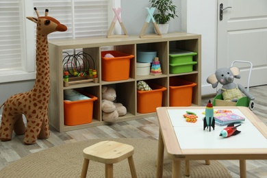 Photo of Cute child's room interior with toys and wooden furniture