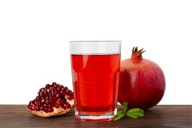 Photo of Refreshing pomegranate juice in glass, leaves and fruits on wooden table against white background
