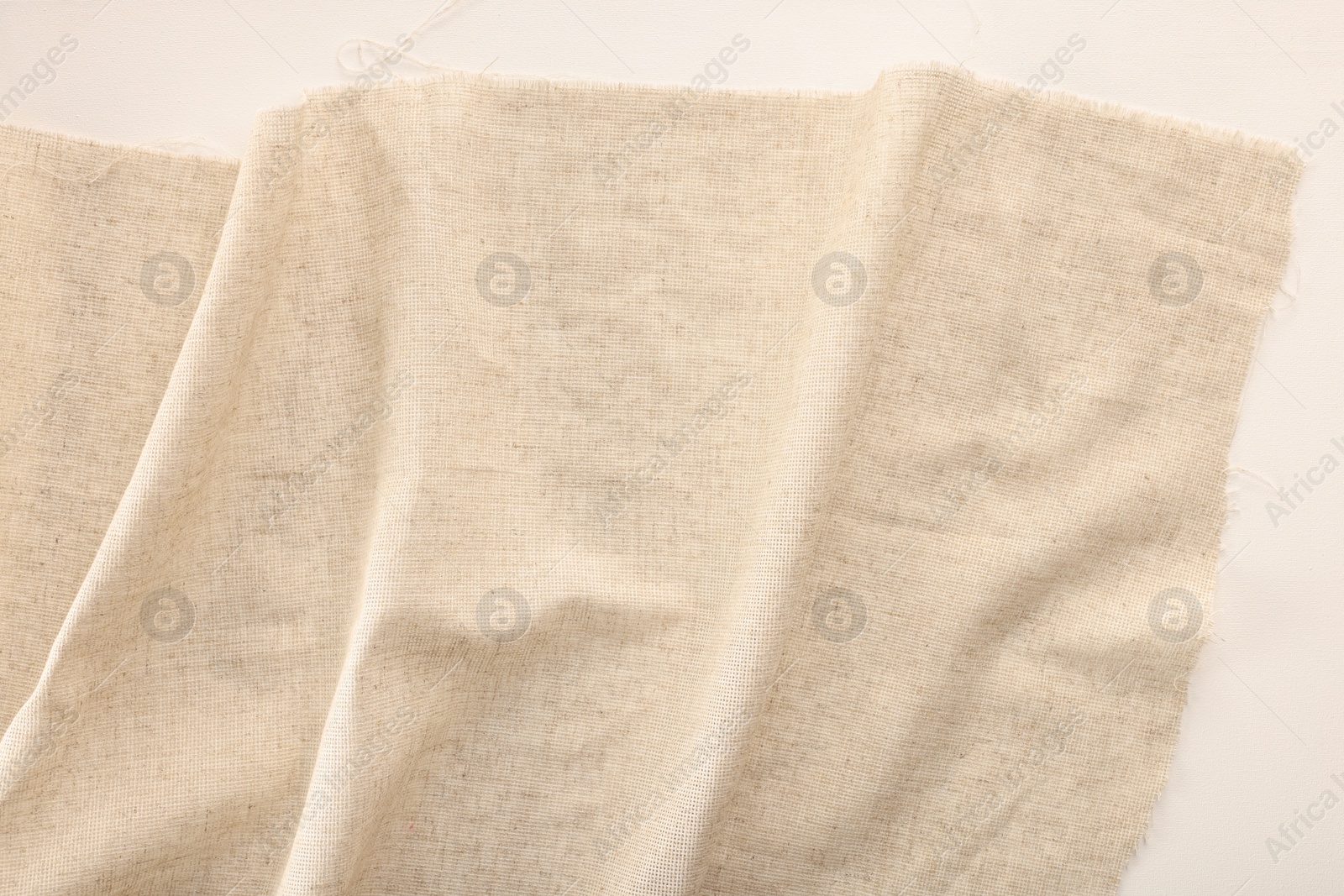 Photo of Natural burlap fabric on white background, top view