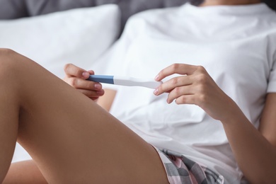 Young woman with pregnancy test, closeup. Gynecology