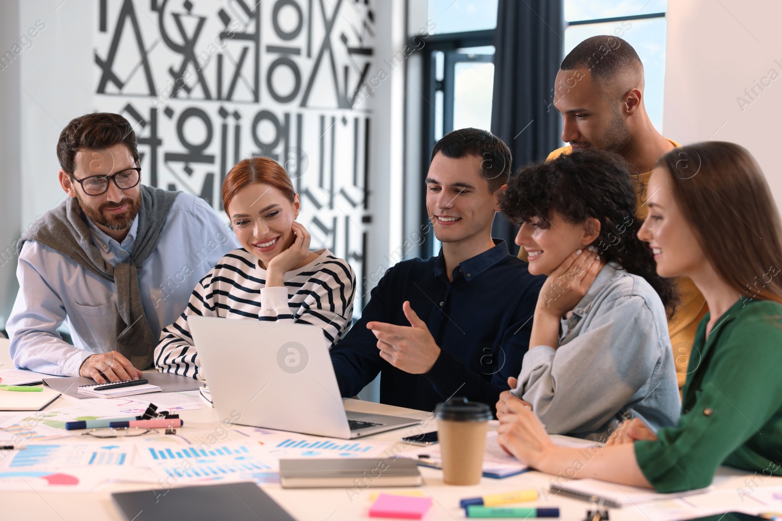 Photo of Team of employees working together at table in office. Startup project