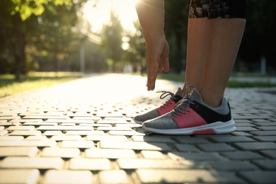 Photo of Woman stretching before morning run in park, closeup. Space for text
