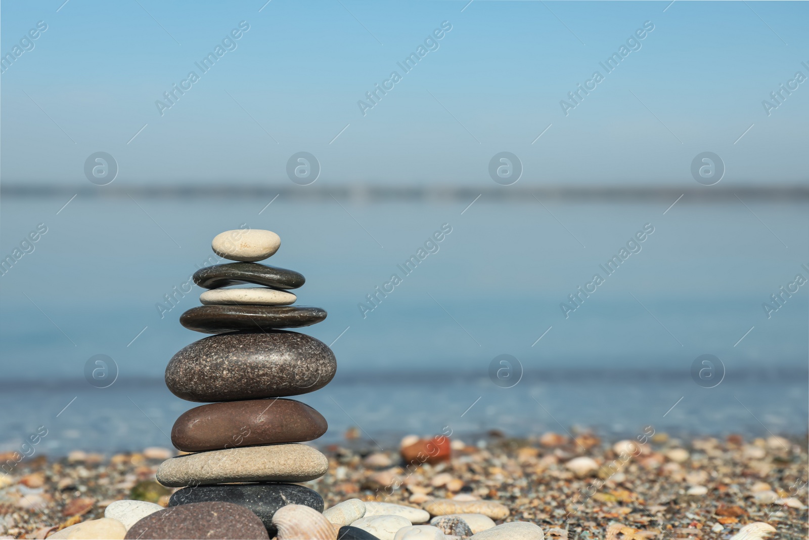 Photo of Stack of stones on beach, space for text. Harmony and balance concept