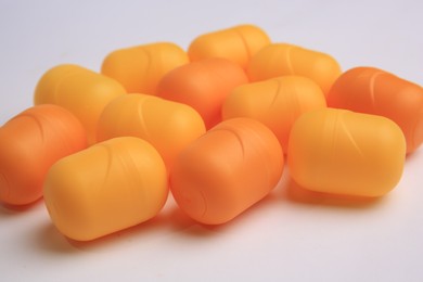 Photo of Sveti Vlas, Bulgaria - June 30, 2023: Orange plastic capsules from Kinder Surprise Eggs on white background, closeup
