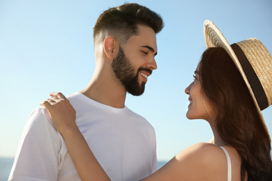 Photo of Happy young couple against blue sky. Honeymoon trip