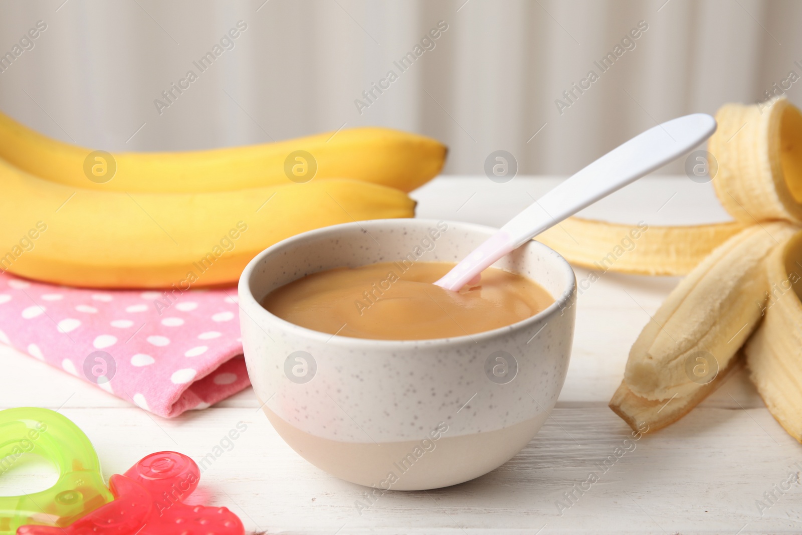 Photo of Bowl of healthy baby food on wooden table