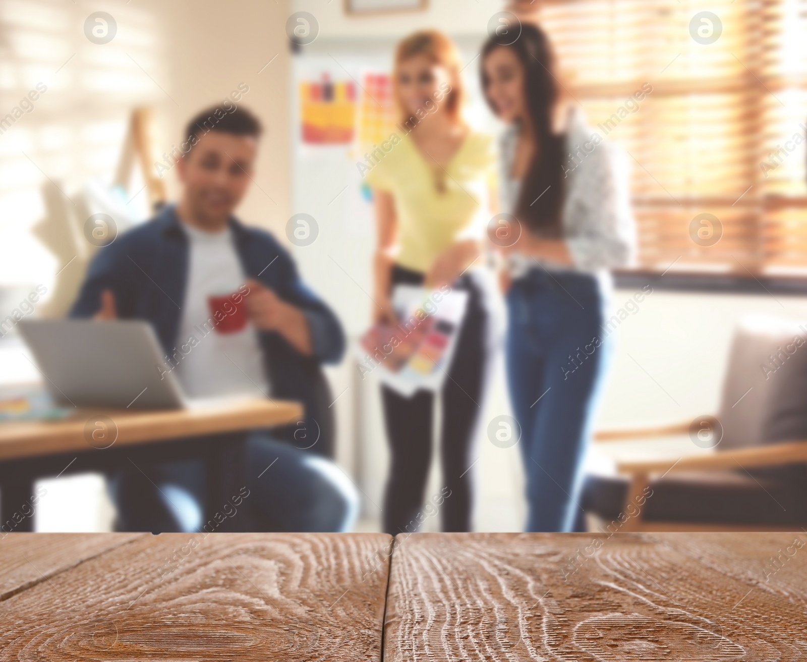 Image of Empty wooden surface and blurred view of professional interior designers working in office, closeup. Space for text 