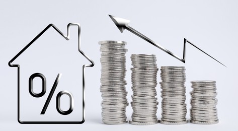Image of Mortgage concept. Many stacked silver coins and house model on light background