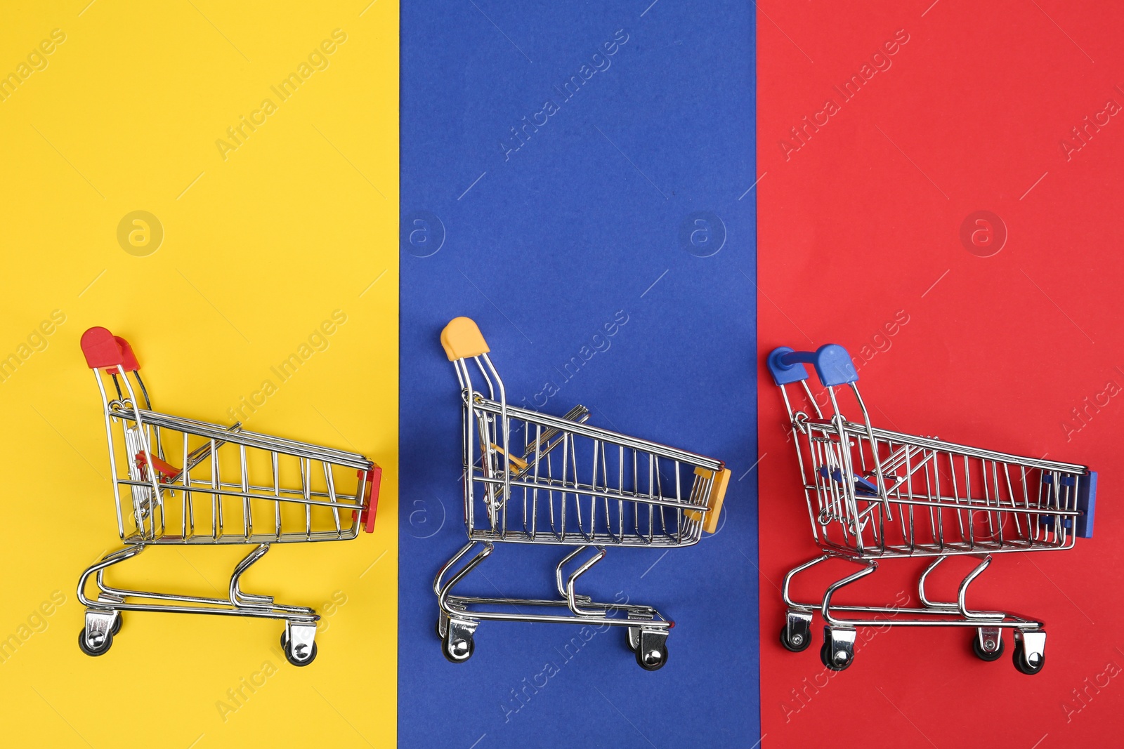 Photo of Flat lay composition with empty shopping trolleys on color background. Space for text