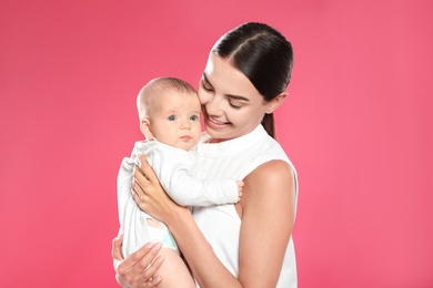 Portrait of happy mother with her baby on color background