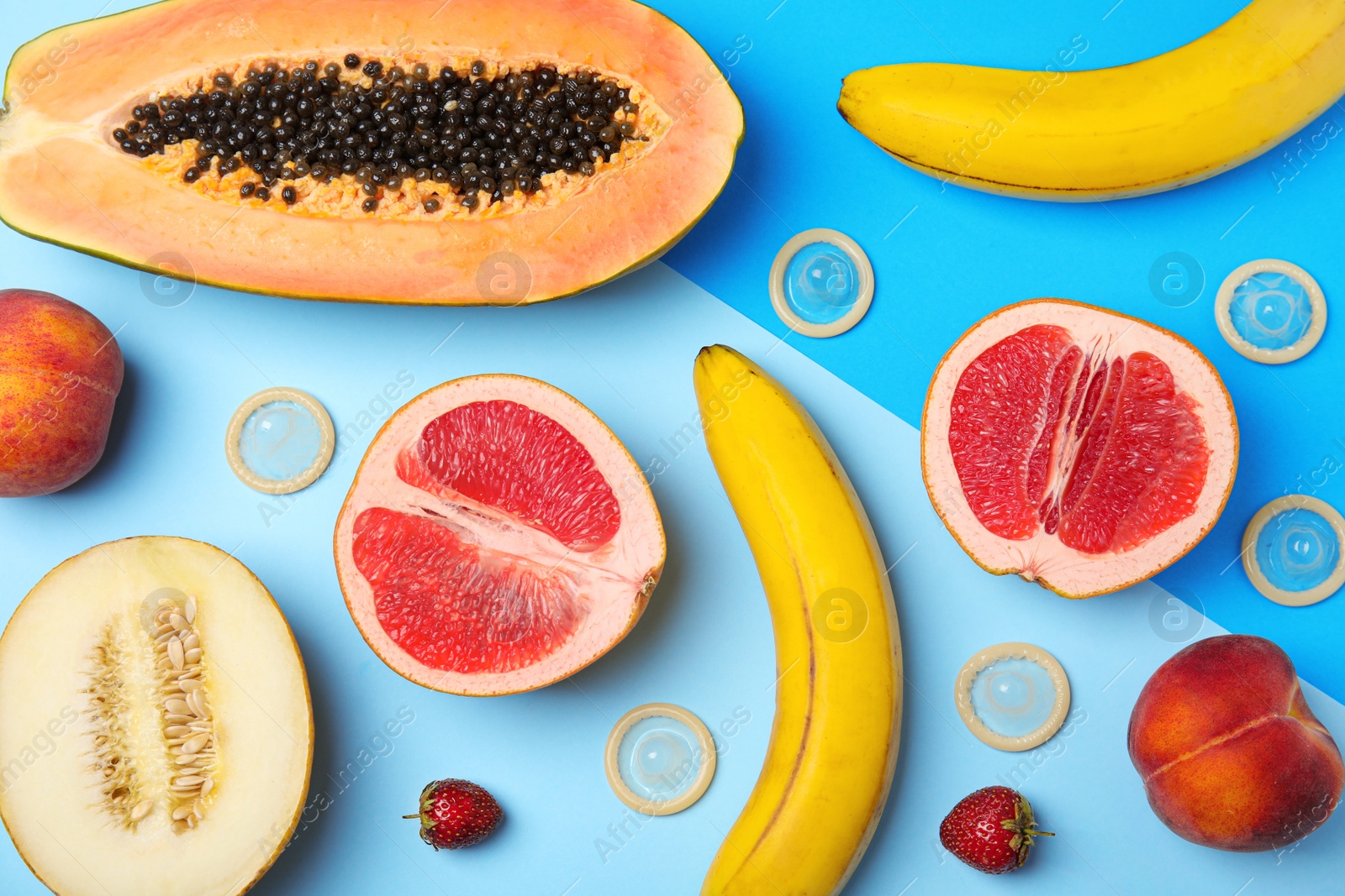 Photo of Flat lay composition with condoms and exotic fruits on color background. Erotic concept