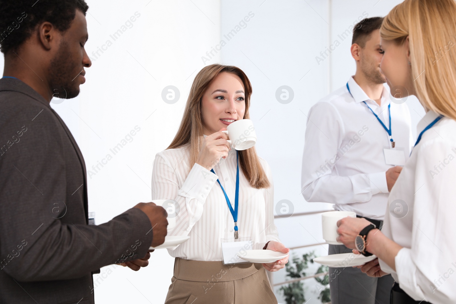 Photo of Group of people chatting during coffee break indoors