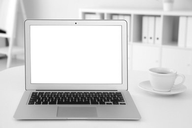 Comfortable workplace with modern laptop on table in office. Mockup for design