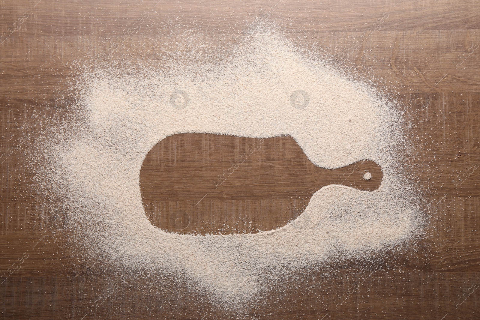 Photo of Imprint of board on wooden table with flour, top view