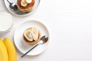 Photo of Banana pancakes served on white wooden table, flat lay. Space for text