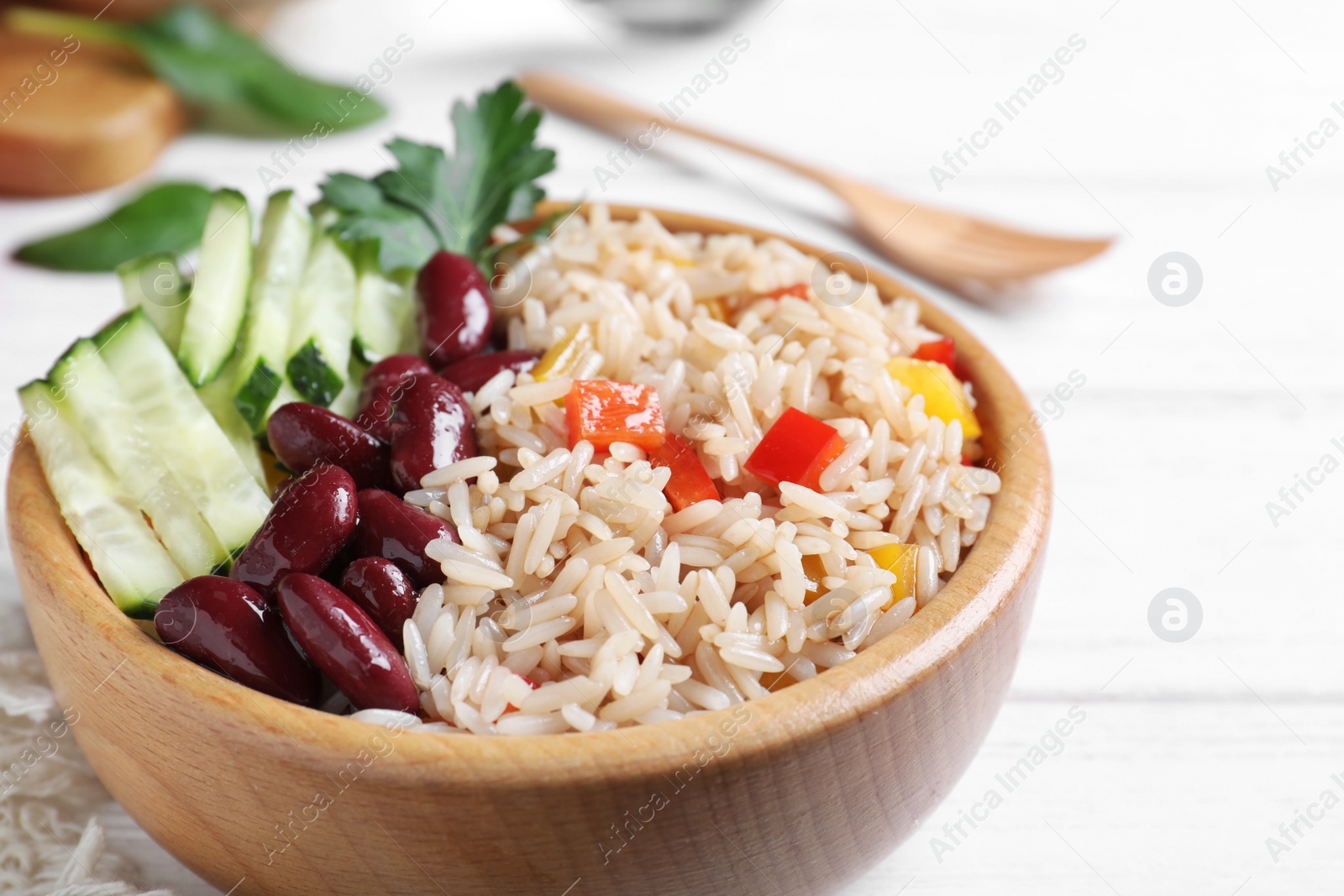 Photo of Delicious rice with beans served on white wooden table, closeup