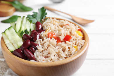 Photo of Delicious rice with beans served on white wooden table, closeup