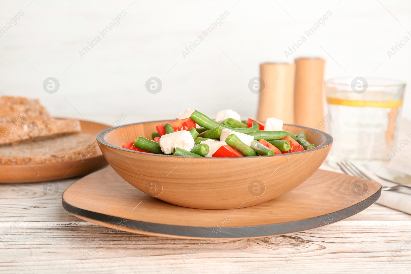 Photo of Plate with tasty green beans, tomatoes and cheese on wooden table